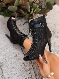 Nahaufnahme der schwarzen Netz-Stiefeletten mit Schnürung und hohen Stiletto-Absatz
