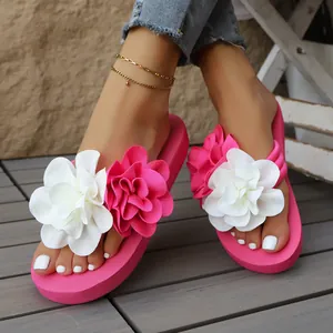 Primer plano de chanclas con plataforma rosas con flores decorativas blancas y rosas