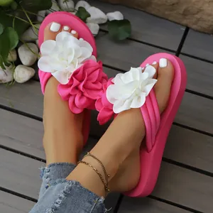 Primer plano de chanclas rosas con plataforma y grandes flores decorativas de tela.