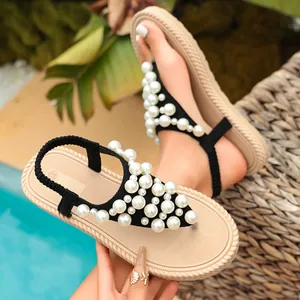 Dettaglio di sandali piatti da donna con eleganti decorazioni di grandi perle per estate