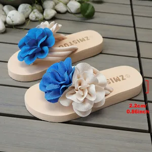 Detalle de chanclas beige con plataforma que muestra 2,2 cm de altura y flores