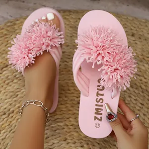 Detalle de las chanclas de plataforma rosa con tiras de flores sobre una alfombra tejida