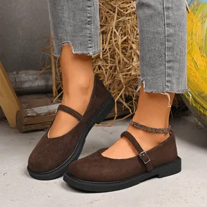 Close-up of brown suede Mary Jane shoes with buckle strap and thick black soles