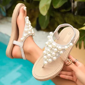Primo piano di eleganti sandali infradito con perle e cinturino elastico posteriore