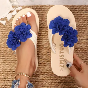 Primer plano de chanclas de plataforma beige para mujer con flores de tela azul