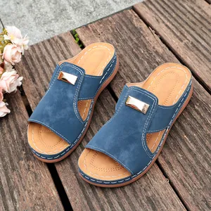 Vue détaillée de sandales compensées bleues pour femmes avec boucle sur terrasse bois