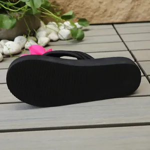 Vista inferior de chanclas de cuña negras con suela antideslizante