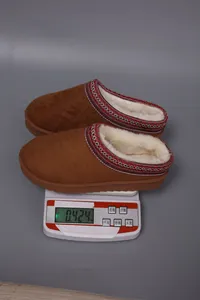 Weight of brown suede winter slippers displayed on a precise digital scale device