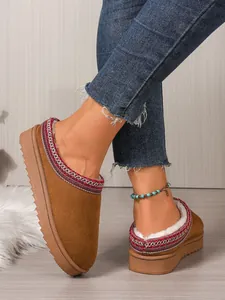 Detailed view of women's brown suede slippers with ethnic trim and soft faux fur lining