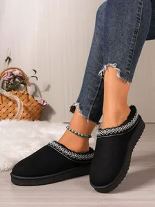 Detail of women's black suede winter slippers with cozy fuzzy lining and soft sole