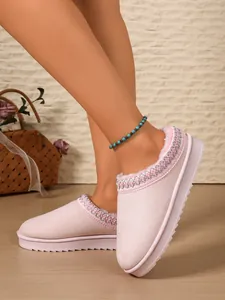 Detail shot of pink suede slippers with cozy faux fur lining and embroidered collar trim