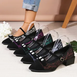 Detail of pointed-toe chunky heel Mary Janes with lace and rhinestone bow details.