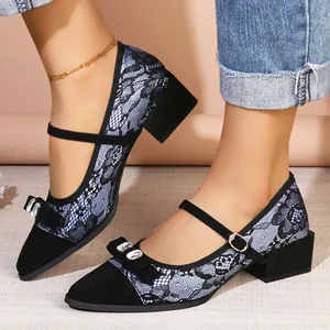 Elegant pointed toe block heel pumps featuring lace patterns and a rhinestone bow detail