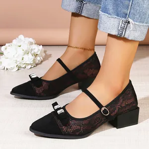 Detail of black lace pointed toe Mary Jane pumps with rhinestone bow and block heel