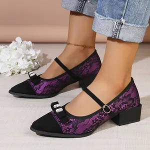 Detail of purple lace Mary Jane shoes with rhinestone bow and block heel.