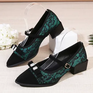 Close-up of elegant green floral lace Mary Jane pumps with crystal bow and block heel.