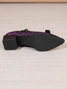 Detailed view of pointed toe block heel shoe with purple lace pattern and bow