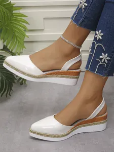 Close-up of white closed-toe wedge sandals with stylish rope-trimmed platform soles.