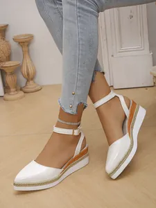 Close-up detail showing the braided rope wedge and white pointed-toe design of these sandals
