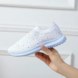 Detailaufnahme von weißen Fly-Knit-Sneakern mit glitzernden Strassstein-Verzierungen.