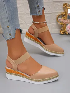Detail view of stylish beige platform wedge sandals featuring woven rope soles and ankle straps.
