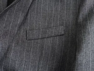 Makroansicht der hochwertigen grauen Nadelstreifen-Stofftextur und Taschendetails