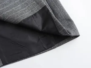 Detailaufnahme von grauem Nadelstreifenstoff und schwarzem Innenfutter eines Kostüms