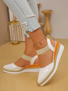 Detailed view of white patent leather platform wedge sandals with elegant straw rope trim