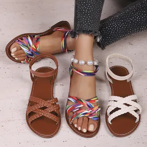Kollektion modischer flacher Damensandalen mit geflochtenen Riemen und bunten Mustern.
