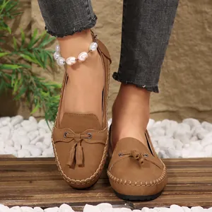 Close-up of brown suede tassel loafers for women in a natural lifestyle setting