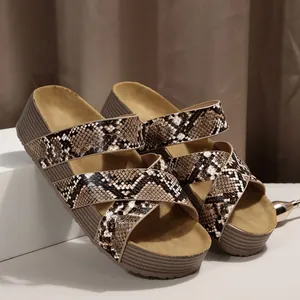 Detailweergave van damesplatformsandalen met kruisbandjes en bruine slangenprint