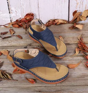 Detailansicht von dunkelblauen Zehentrenner-Sandalen mit Wellenstickerei und Keilsohle