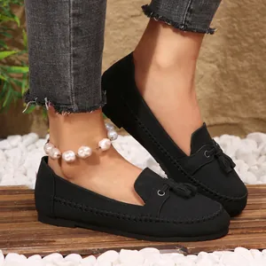 Elegant black suede loafers for women with stylish tassel detail on wooden deck