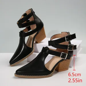 Détail du talon bloc de 6,5 cm sur des bottines noires à bout pointu et boucles triples
