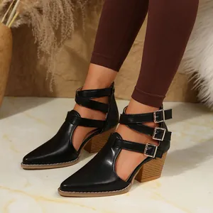 Gros plan sur les bottines noires rétro à bout pointu avec triple brides à boucle