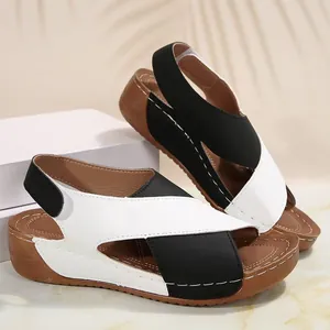 Vista detallada de sandalias de cuña bicolores con correas cruzadas negras y blancas