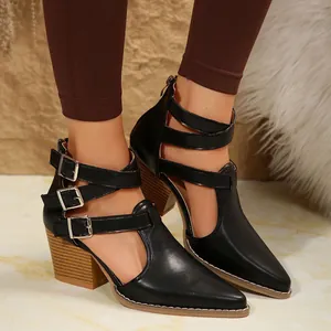 Détail du bout pointu et des boucles en métal sur des bottes noires à talon épais