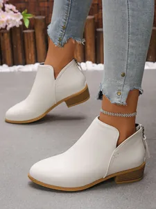 Detailed view of white pointed-toe ankle boots with back zipper and chunky heel