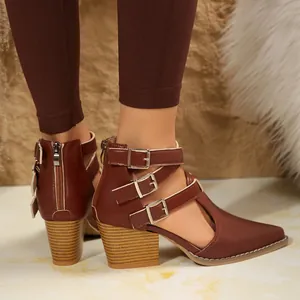 Gros plan de bottines marron à bout pointu et talon épais avec boucles décoratives chic