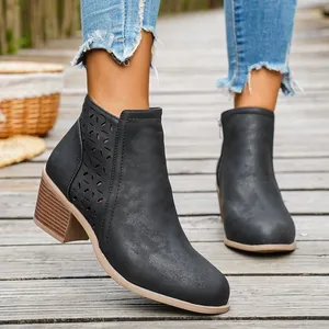 Zwarte enkellaarsjes voor dames met blokhak en lasergesneden bloemendetails.