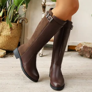 Close-up of brown knight boots featuring leather and suede splicing with buckle detail