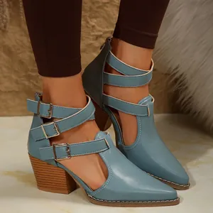 Gros plan de bottines rétro bleues à talons blocs et brides à boucles sur un mannequin.