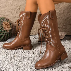 Vintage brown mid-calf western cowboy boots with white embroidery and lace-up design