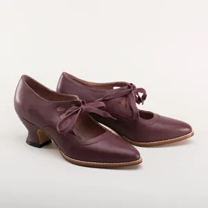 Detailed side view of elegant burgundy leather heels with lace-up ribbons and cutouts.