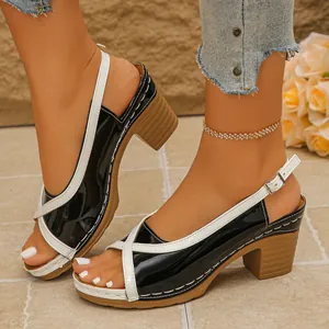 Elegant zijaanzicht van tweekleurige sandalen met blokhak en enkelbandsluiting.