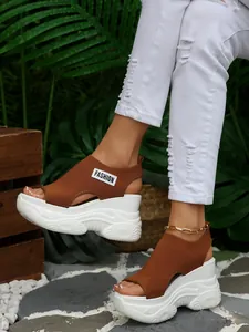Stijlvolle bruine fly-knit sandalen met sleehak, witte plateauzool en peep-toe ontwerp