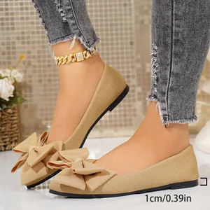Side view of beige pointed toe flats with bow detail and 1cm heel height.
