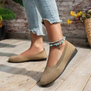 Close-up of breathable khaki knit flat shoes for women on a stylish wooden deck.