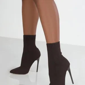 Nahaufnahme von eleganten dunkelbraunen spitzen Stiletto-Socken-Stiefeletten für Damen