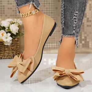 Elegant champagne gold pointed-toe flats with large bow decoration for women